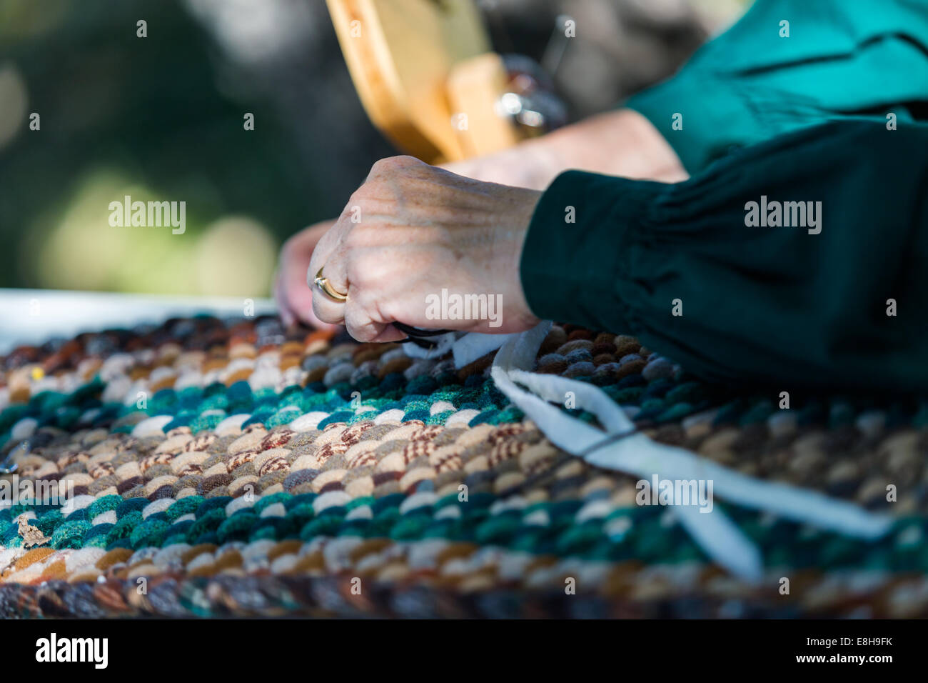 La realizzazione di un tappeto con materiali vintage dalla vecchia donna. Foto Stock