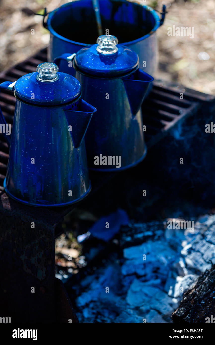 Pentole di acqua bollente sul campeggio una buca per il fuoco a legna. Foto Stock