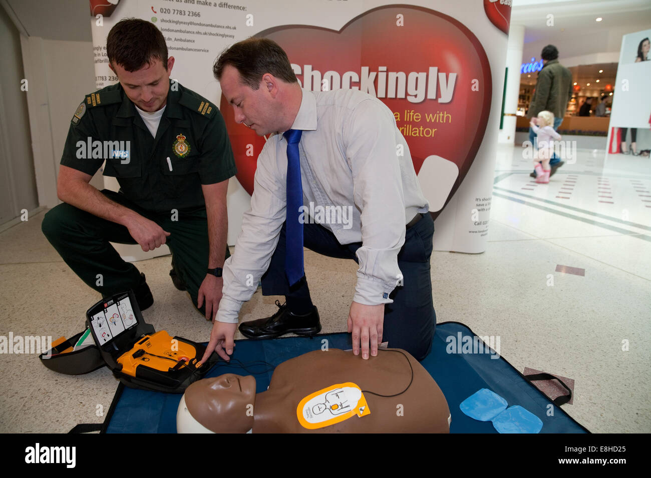 Il consigliere Pietro Fortune è rappresentato da un LAS membro dello staff come utilizzare un defibrillatore all'evento di formazione in intu shopping center a Bromley Foto Stock