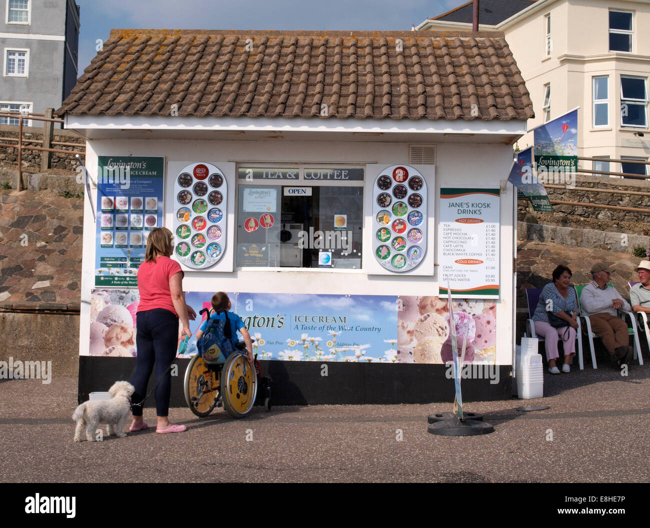 Giovane ragazzo in una sedia a rotelle in corrispondenza di un chiosco di gelati, Seaton, Devon, Regno Unito Foto Stock