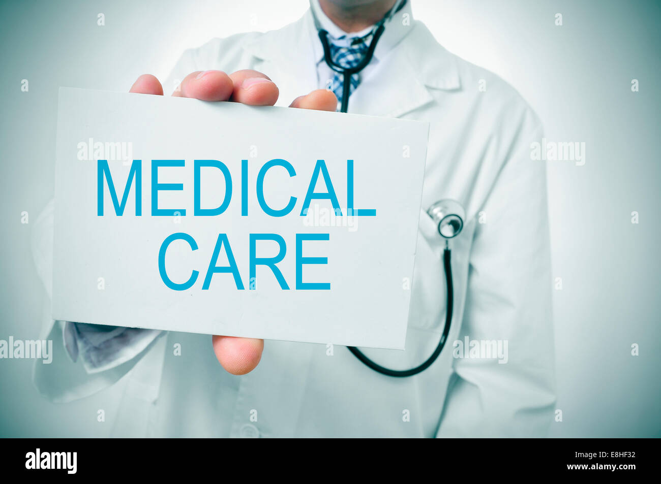 Un medico mostrando un cartello con scritto il testo di cure mediche scritte in essa Foto Stock