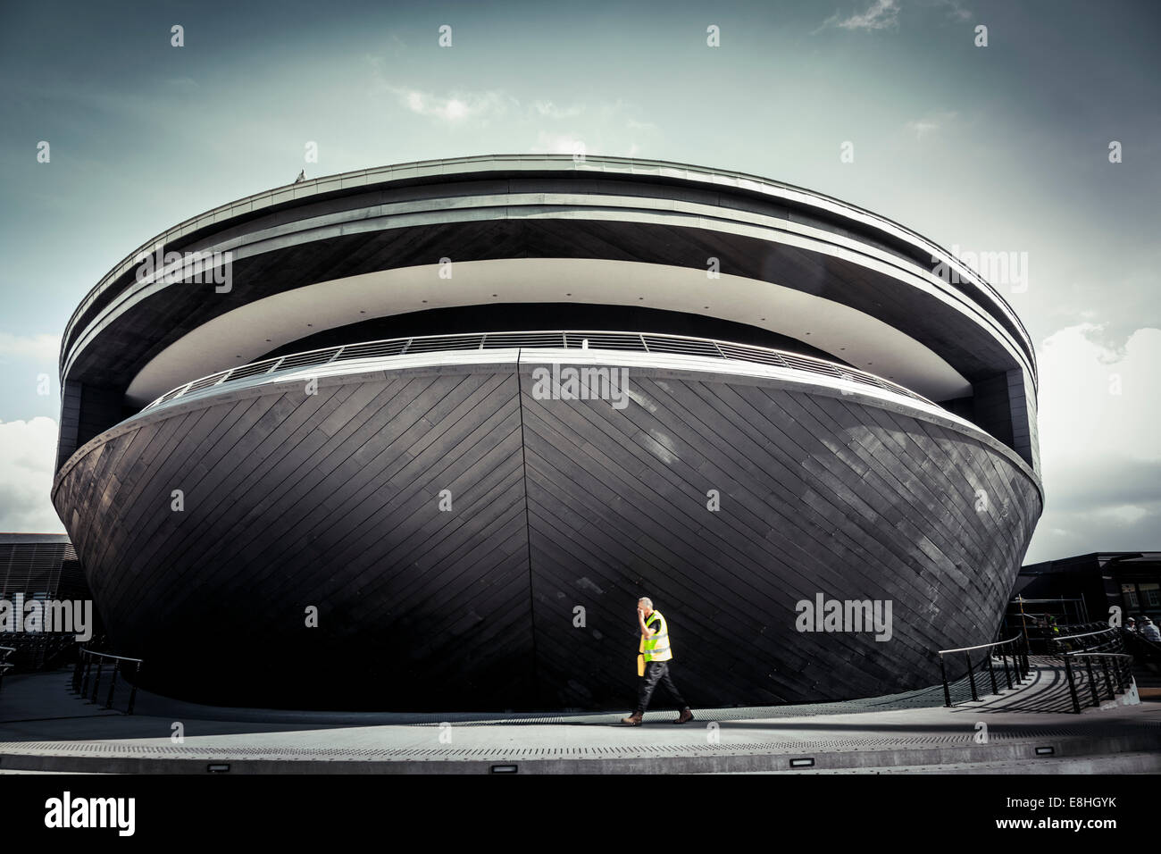 Un lavoratore in un hi-viz giacca passeggiate nella parte anteriore del nuovo (2013) Mary Rose museo nel Royal Naval Dockyard di Portsmouth Foto Stock