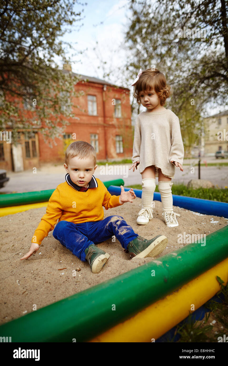 Un ragazzo e una ragazza la riproduzione in sandbox Foto Stock