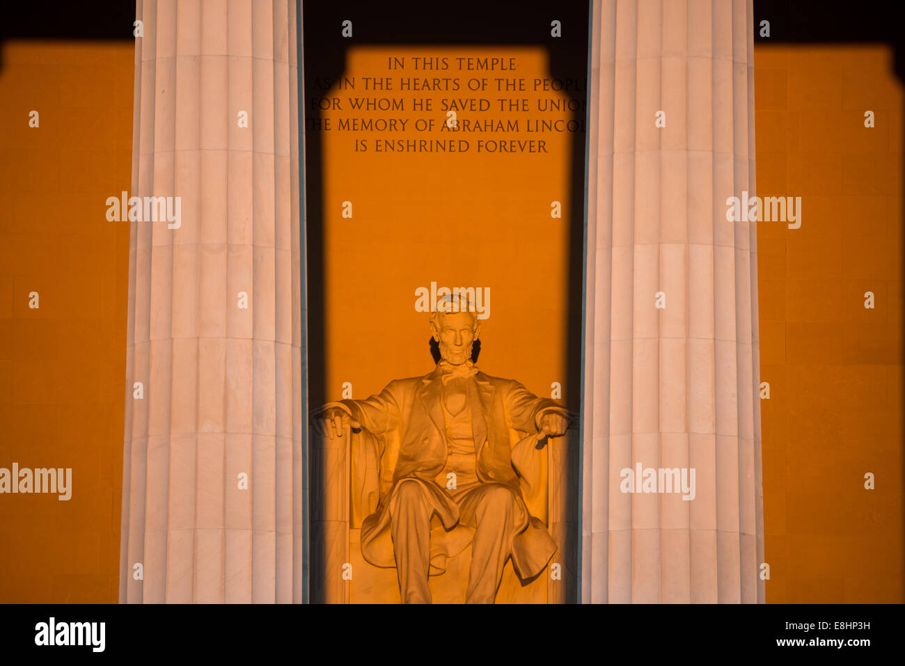 WASHINGTON DC, Stati Uniti d'America - una luce dorata momenti dopo l'alba si crogiola la statua di Abramo Lincoln nel Lincoln Memorial a Washington DC. Questo evento si verifica solo in alcuni periodi dell'anno con un chiaro tramonto quando il sole sta sorgendo direttamente in oriente per l'Equinozio. Foto Stock