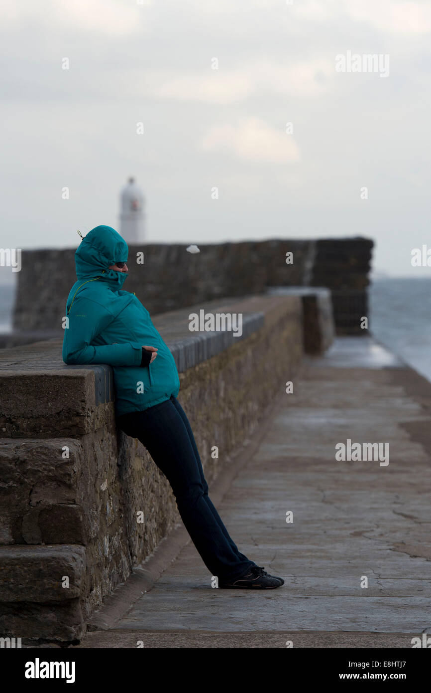 Una giovane ragazza viene soffiata dal vento a Porthcawl, Galles. Foto Stock