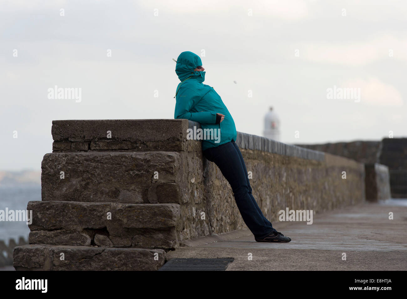 Una giovane ragazza viene soffiata dal vento a Porthcawl, Galles. Foto Stock