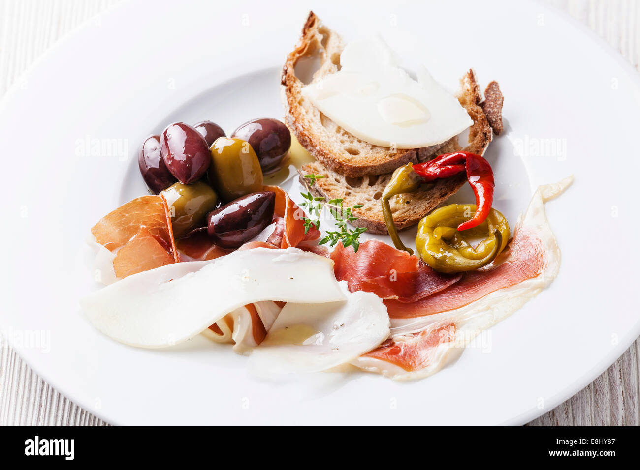 Antipasto con prosciutto e formaggio e olive su piastra bianca Foto Stock