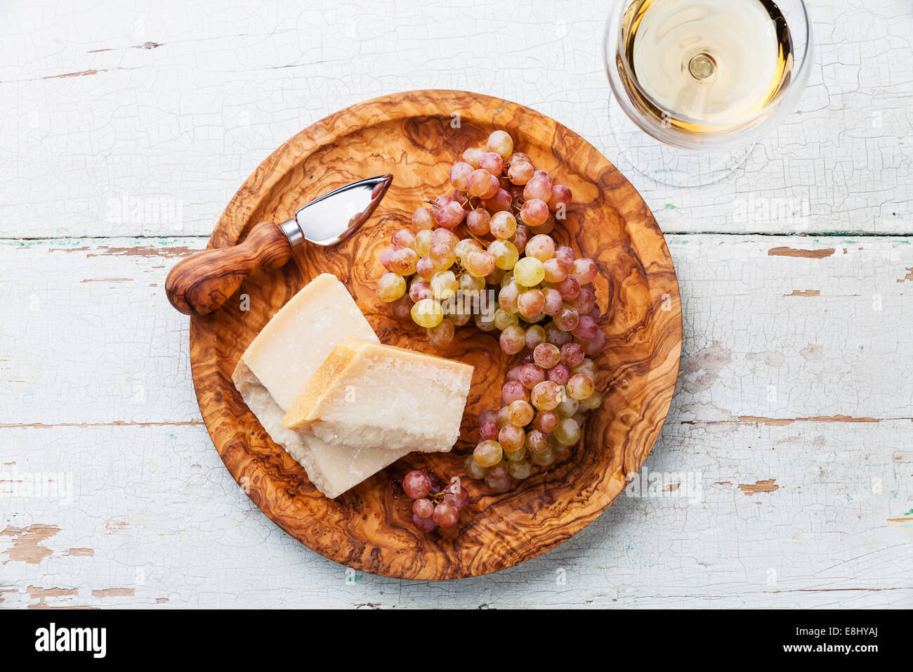 Formaggio parmigiano e kishmish uve in legno d'ulivo piastra e vino Foto Stock