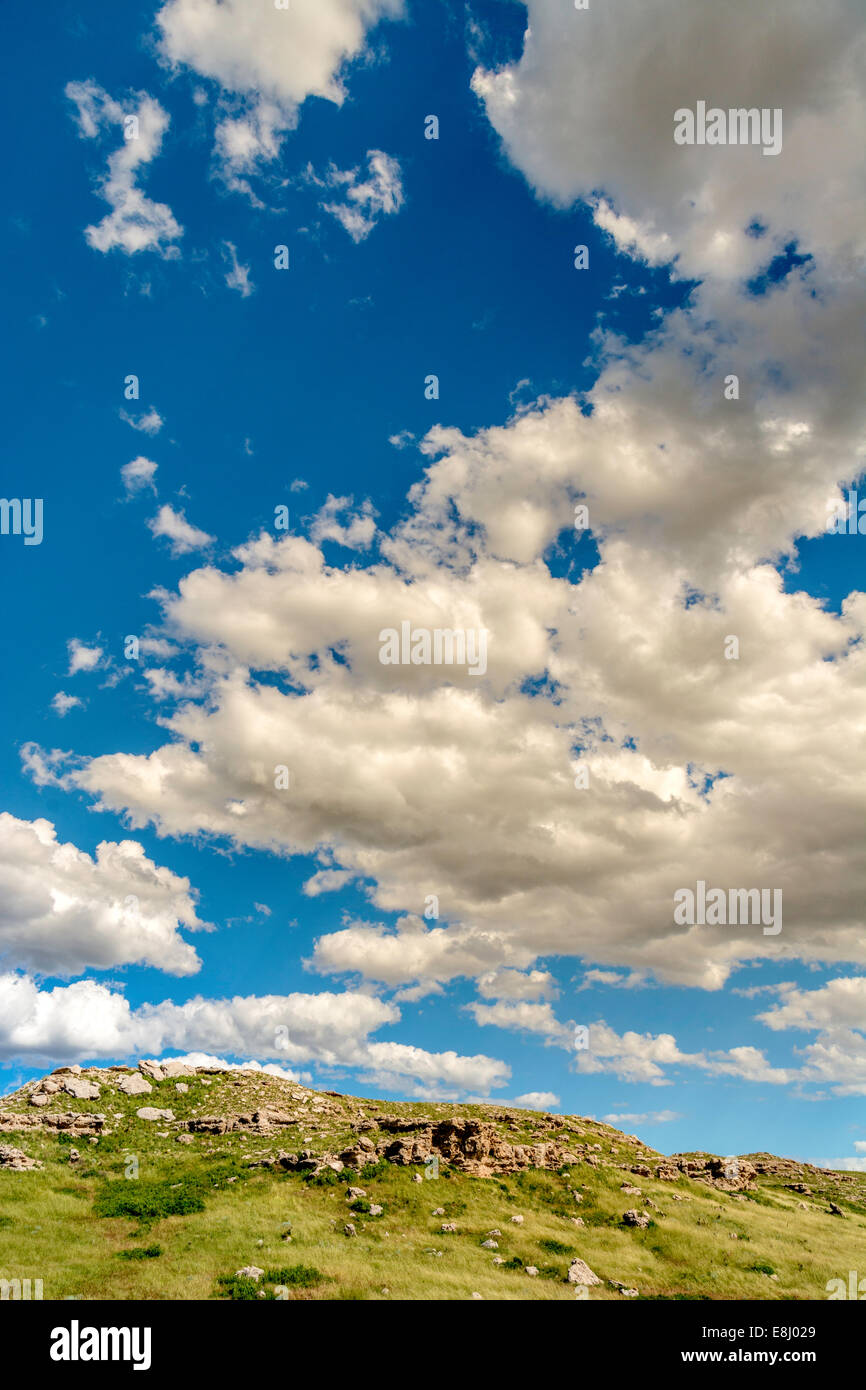 Drammatica cloudscape sopra una piccola collina erbosa Foto Stock