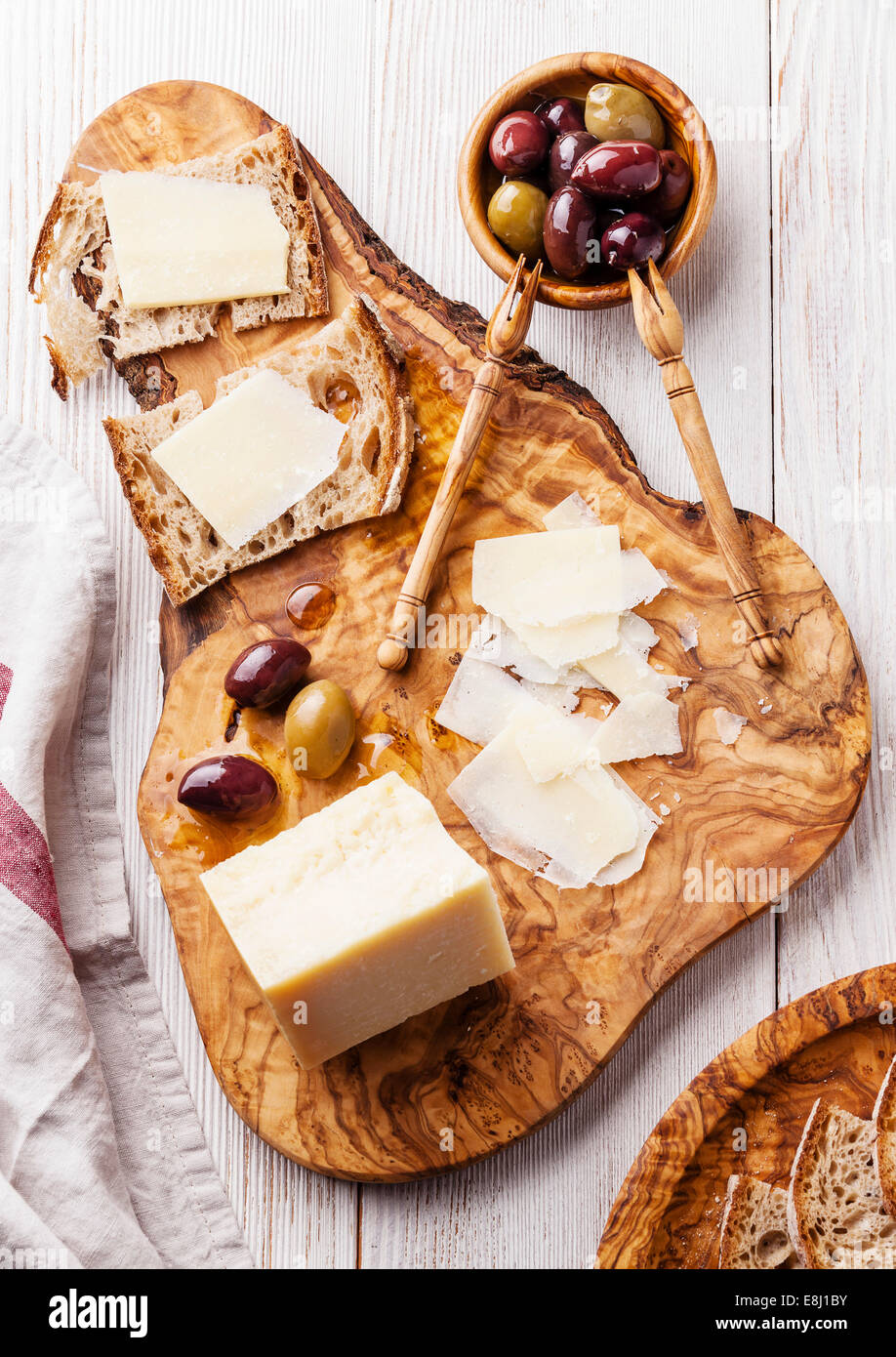 Panini con formaggio parmigiano e olive su legno d'ulivo tagliere Foto Stock