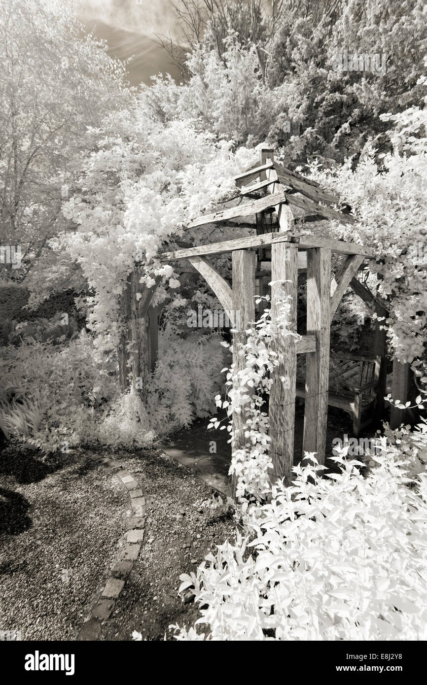 Fotografia a infrarossi di un classico giardino inglese, gazebo in legno di quercia a Wollerton Old Hall (NGS) Market Drayton nello Shropshire summe precoce Foto Stock