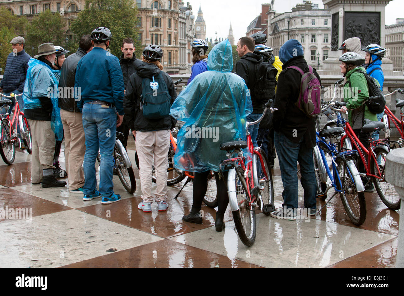 Persone su tour in bicicletta in condizioni di bagnato, Trafalgar Square, London, Regno Unito Foto Stock
