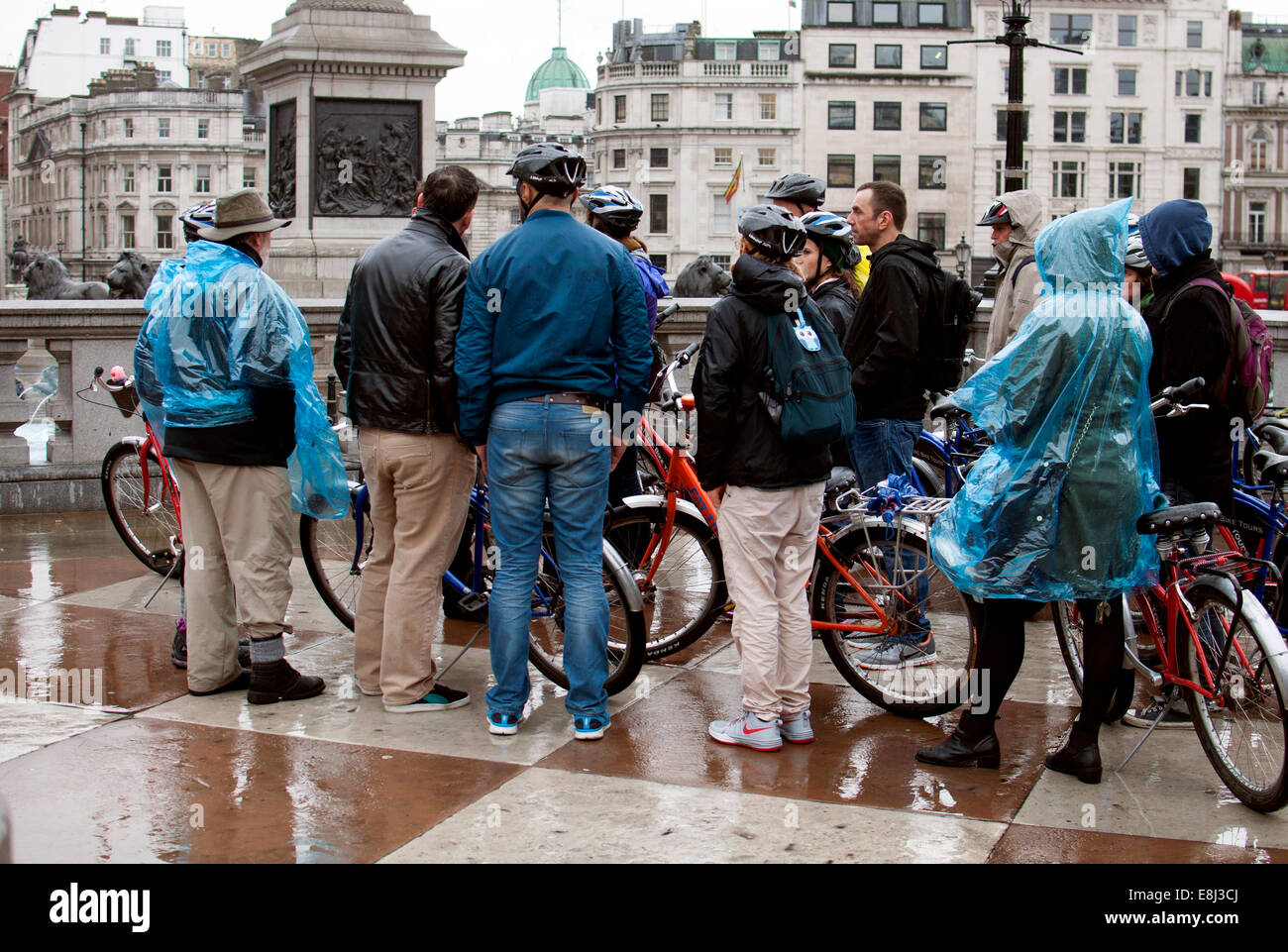Persone su un tour in bicicletta in condizioni di bagnato, Trafalgar Square, London, Regno Unito Foto Stock