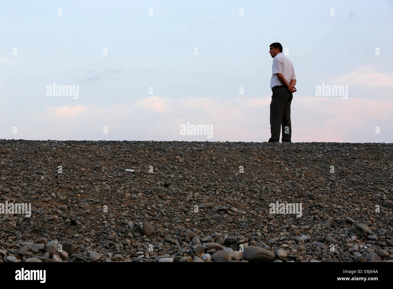 Uomo in attesa dal lato di una strada Foto Stock