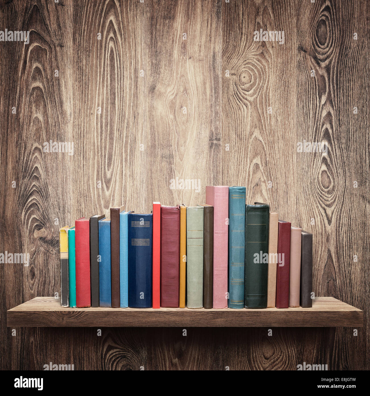 Vecchi libri su uno scaffale di legno. Foto Stock