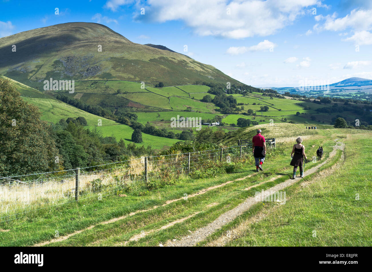 dh Latrigg KESWICK LAKE DISTRICT coppia camminando cane sentiero cumbria Hill uk cumbria National Park percorso rurale campagna inglese paese Foto Stock