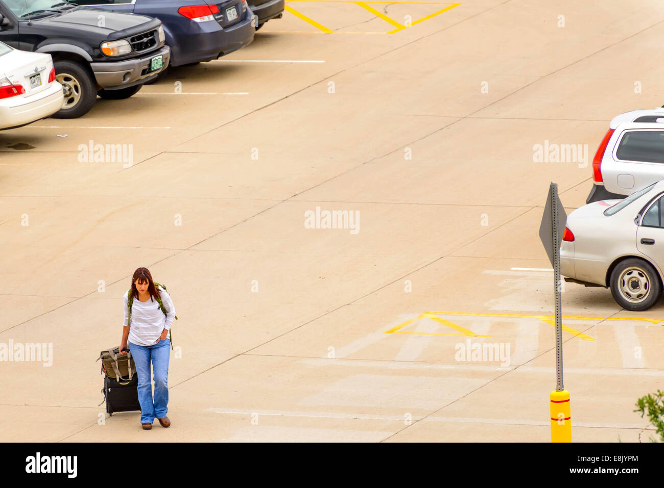 DIA, DEN, Aeroporto Internazionale di Denver, CO - la persona a piedi con i bagagli per il parcheggio esterno Foto Stock