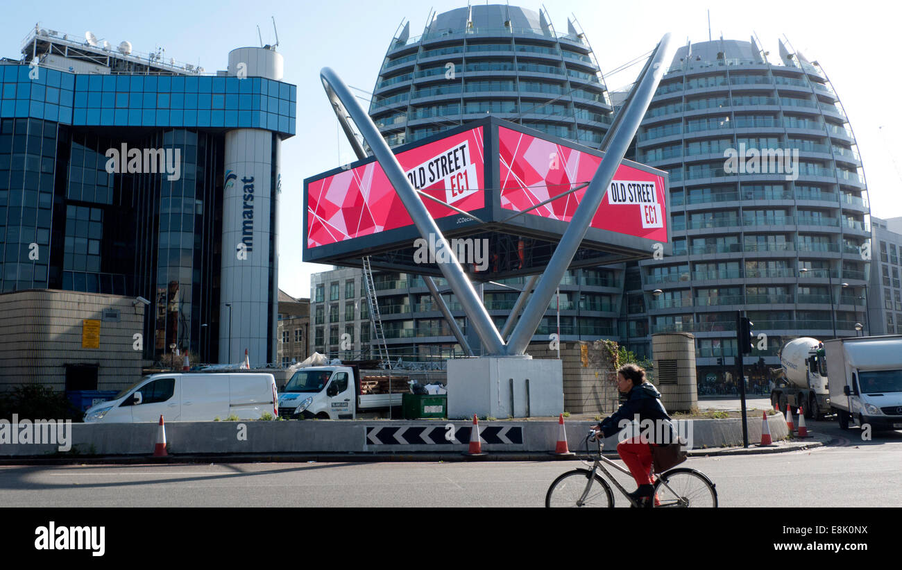 Londra, Regno Unito. Il 9 ottobre, 2014. In autunno sole un ciclista naviga la vecchia strada 'Silicon' rotatoria a mezzogiorno in passato la vecchia strada CE! Segno. Nonostante una piovosa outlook meteo del giorno continua ad essere estremamente ventoso ma asciutto nel pomeriggio. Credito: Kathy deWitt/Alamy Live News Foto Stock
