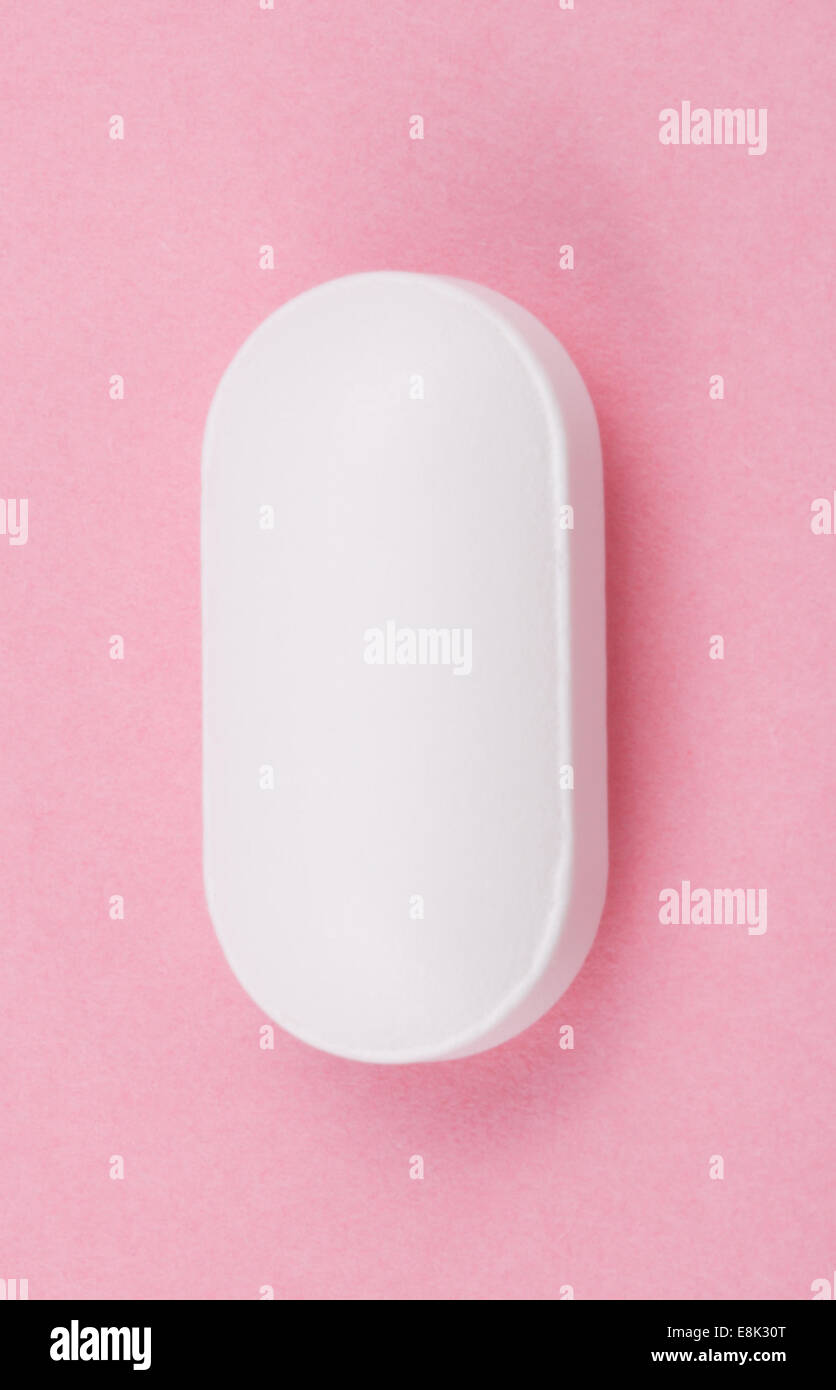 Pillola bianco su sfondo rosa Foto Stock