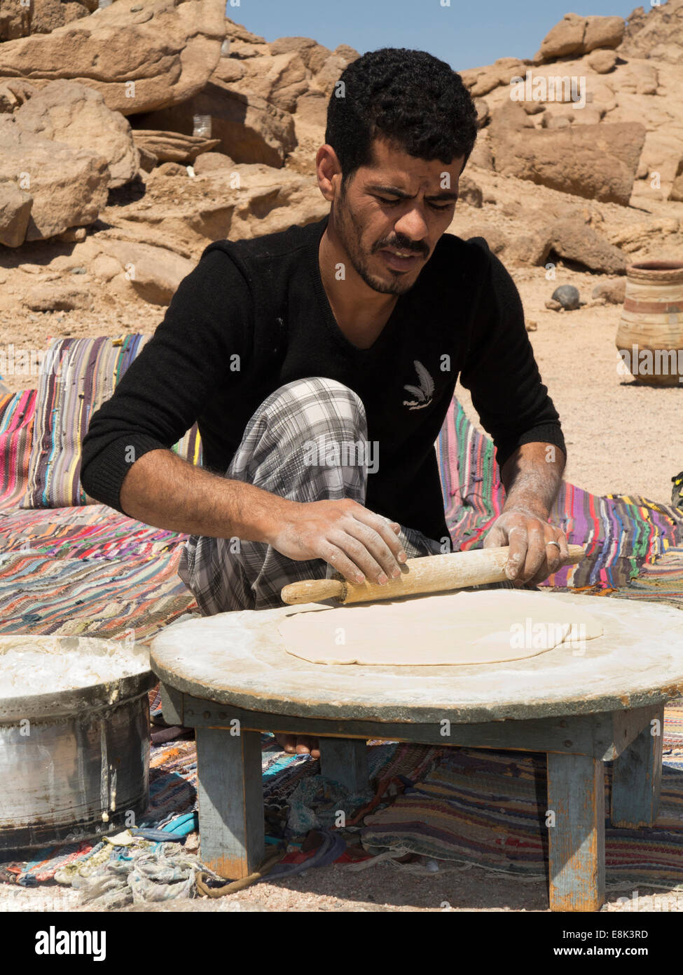 L'Egitto, il Sinai,Beduino Desert Camp, uomo rolling out fatir tradizionale pane piatto piatto di pasta Foto Stock
