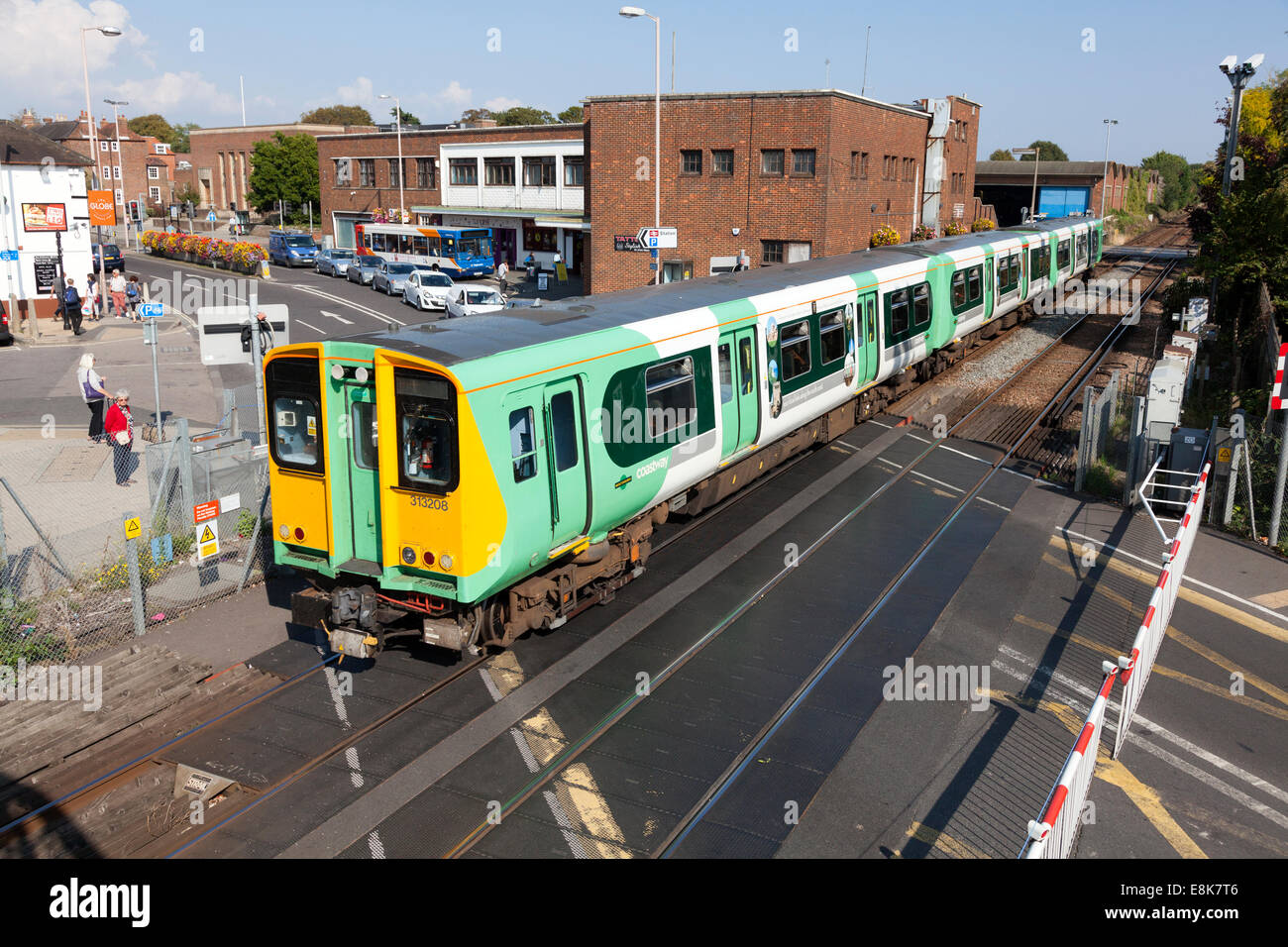 Sud del convoglio ferroviario che passa oltre il passaggio a livello, Chichester, West Sussex Foto Stock