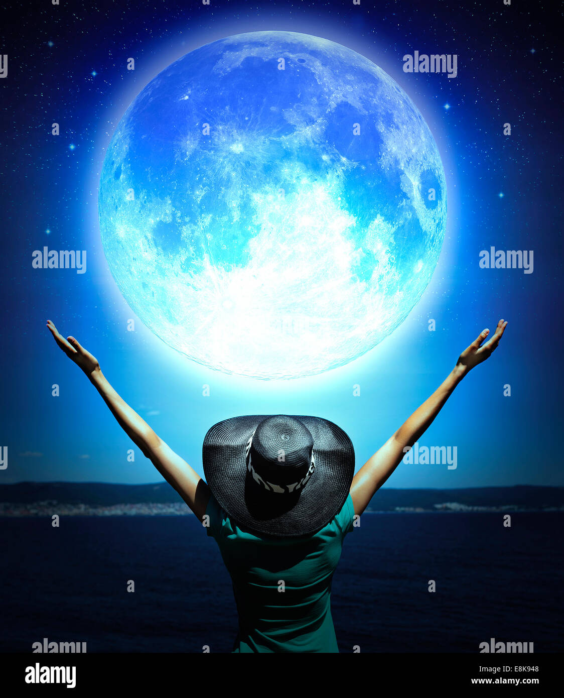 Donna con le mani alzate di fronte ad un onda e luna piena Foto Stock