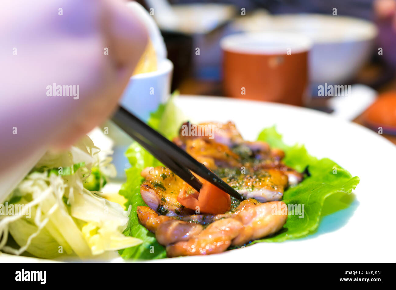 Bacchette mano Pollo grigliato con uovo e insalata deliziosa Foto Stock