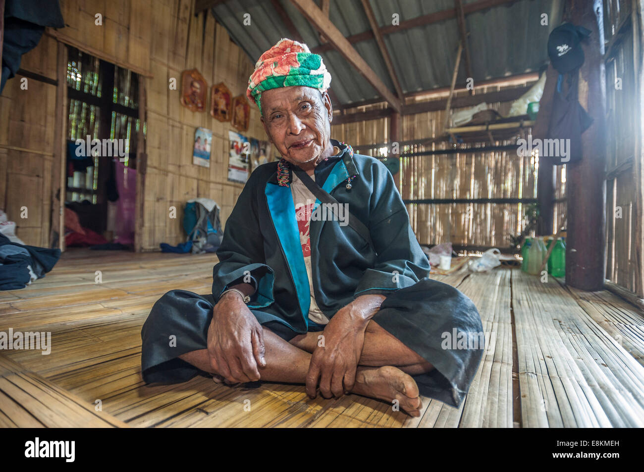 Anziani uomo sorridente dal popolo Lahu, hill tribe, appartenenti a una minoranza etnica, seduti sulla veranda, Mae Hong Song Provincia Foto Stock