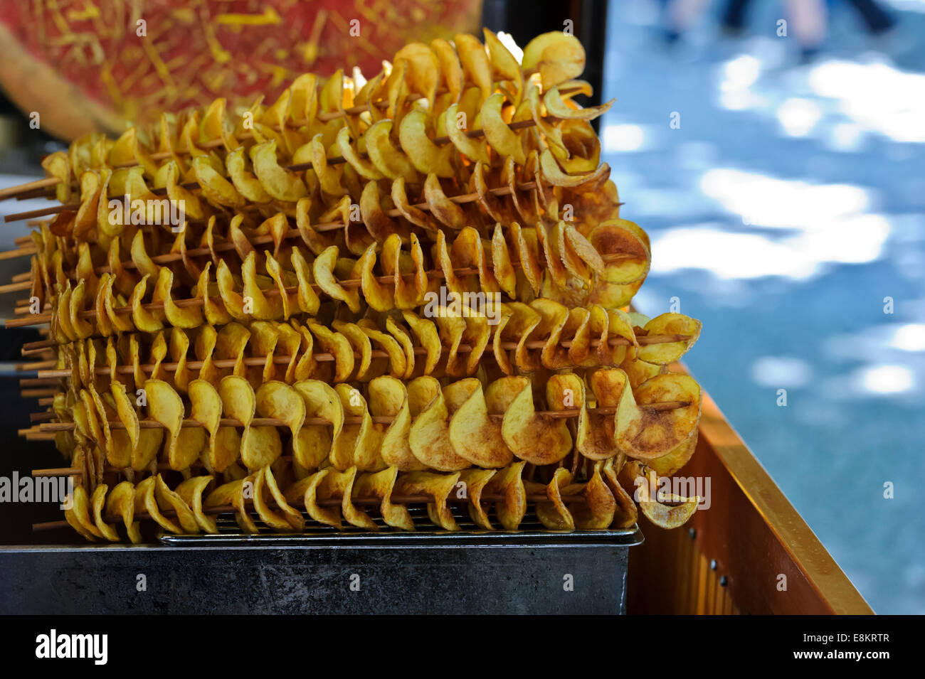 Fried sottili fette di patate su bastoni in vendita nella città di Praga, Repubblica Ceca. Foto Stock