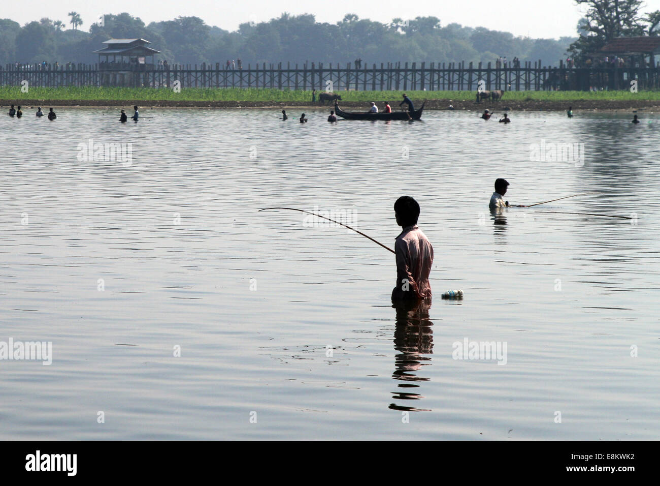 La pesca in lago Taungthaman con U Bein's Bridge in background, in Amarapura, Birmania (Myanmar) Foto Stock