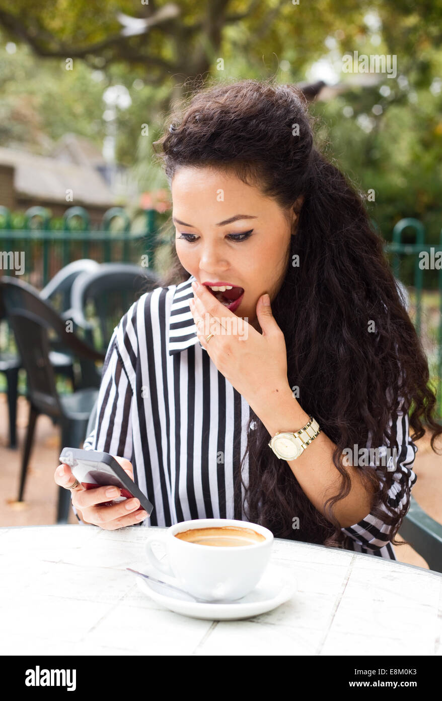 Giovane donna guardando sorpreso un messaggio. Foto Stock