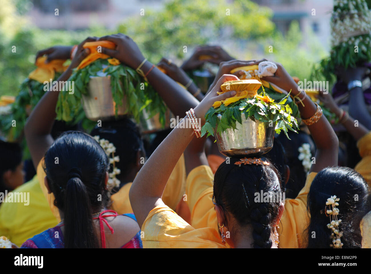 Femmina indù devoti che porta bicchieri di latte sulla testa in festa religiosa, vista posteriore Foto Stock