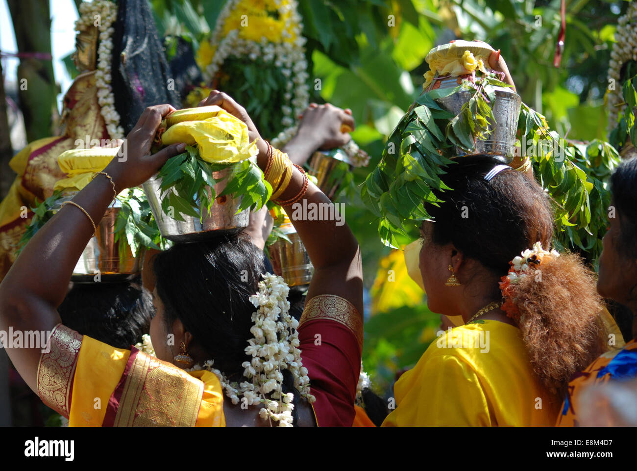 Femmina indù devoti che porta bicchieri di latte sulla testa in festa religiosa, vista posteriore Foto Stock