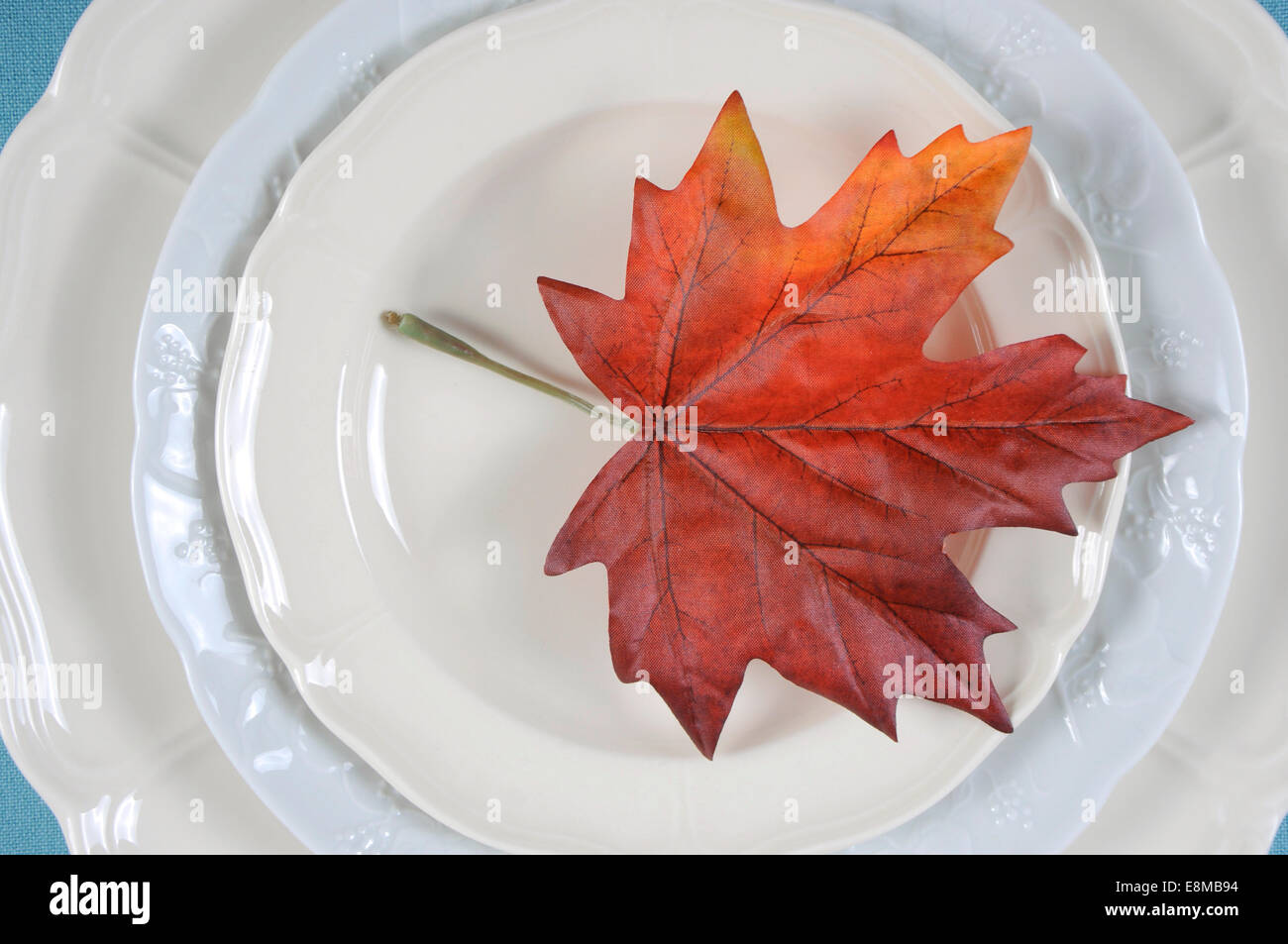 Felice ringraziamento tavolo da pranzo elegante luogo impostazione in pallide aqua blu e bianco tema con foglie di autunno. Close up. Foto Stock