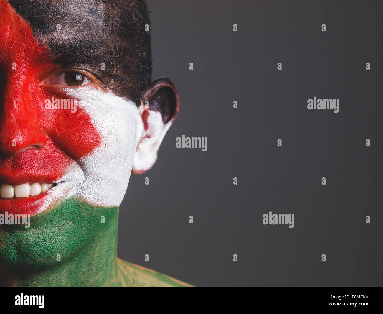 L uomo e il suo volto dipinto con la Palestina bandiera isolato su sfondo scuro Foto Stock