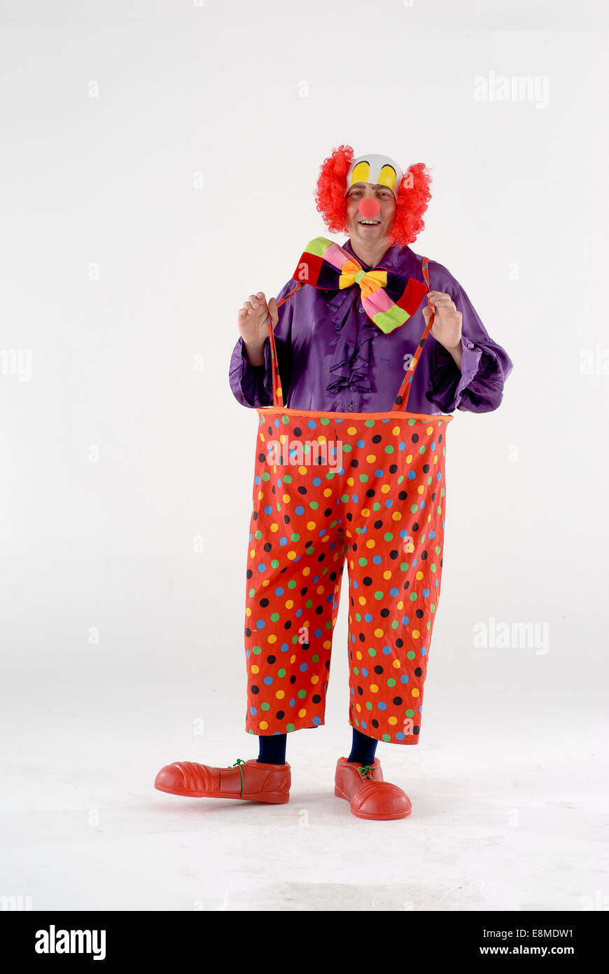 Uomo vestito in abiti fantasiosi costumi di commedia in un circo clown  outfit divertente con parrucca e vestiti larghi, giant shoes & naso rosso  Foto stock - Alamy