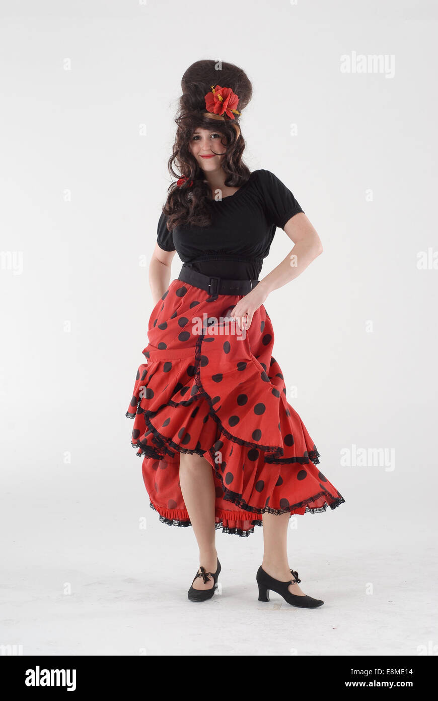 Donna in costume costume di commedia in una salsa spagnolo / flamenco  vestito con abito rosso, nero in alto e grande parrucca Foto stock - Alamy