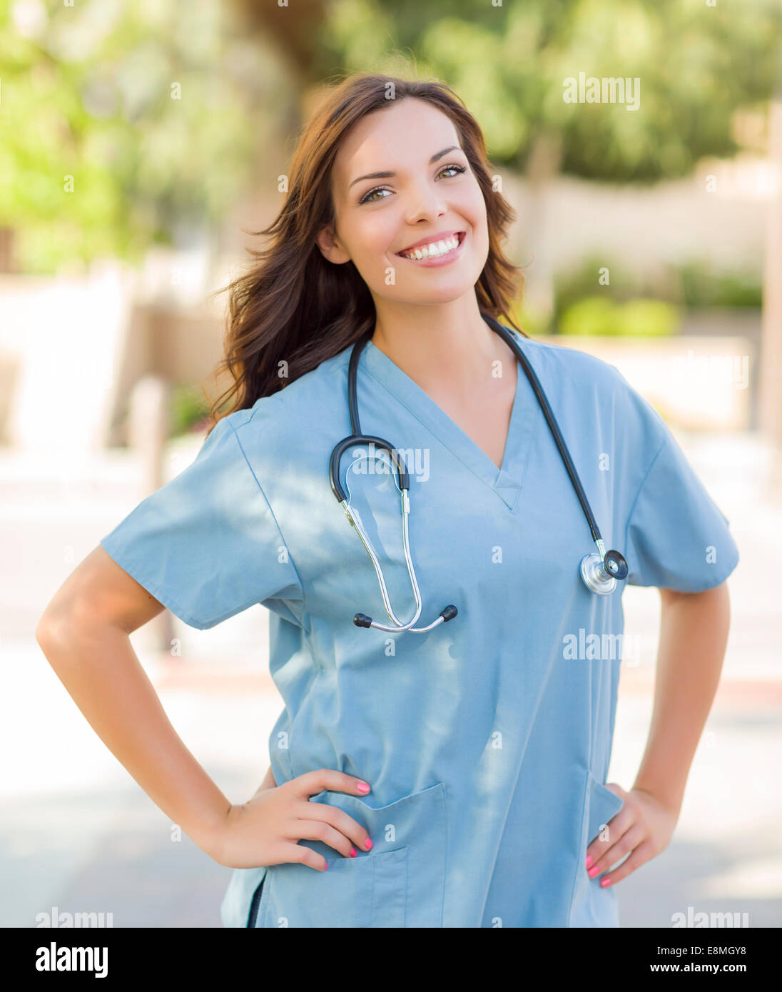 Orgogliosa attraente giovane donna adulta medico o infermiere ritratto all'esterno. Foto Stock