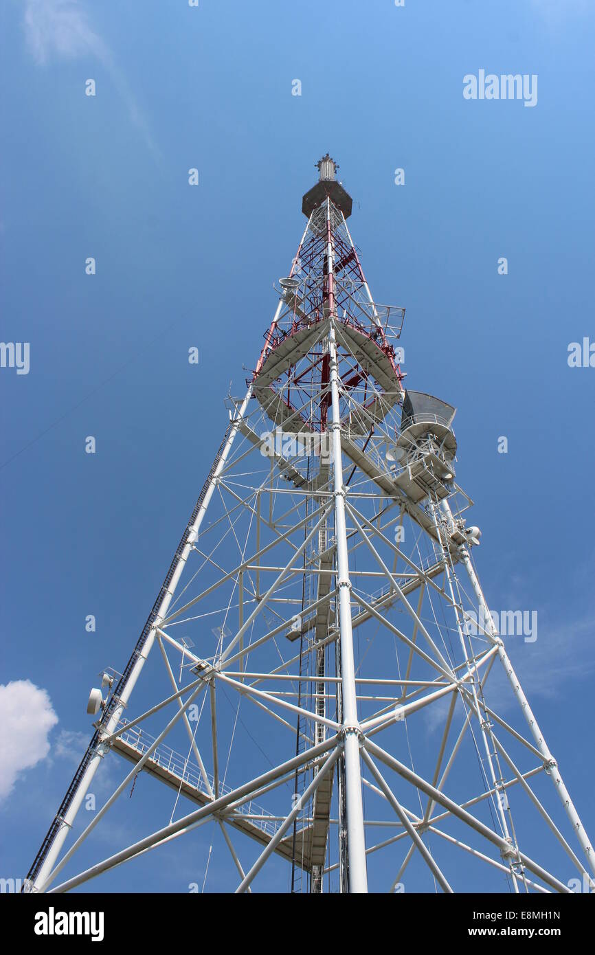 Alta torre telecom su uno sfondo di cielo blu Foto Stock