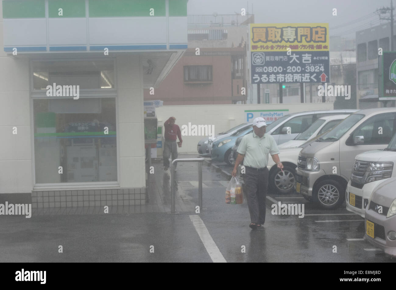 Okinawa, in Giappone. Undicesimo oct, 2014. 12.51pm alcuni Okinawans fare un rush finale per la famiglia Mart 24-hour convenience store prima che essa si chiuda a 1pm a causa della forza del Super Typhoon Vongfong. Credito: Chris Willson/Alamy Live News Foto Stock