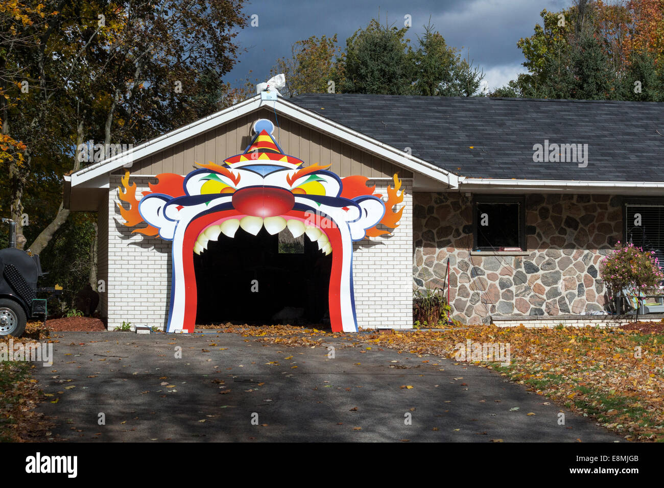 Scary spaventoso enorme clown faccia con denti che copre l'entrata di un garage decorata per Halloween. Foto Stock