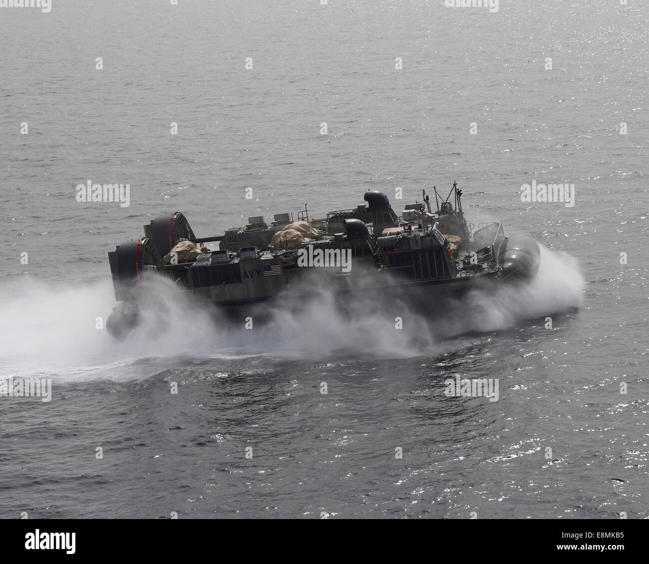 Mare Arabico, 6 Aprile 2014 - Una Landing Craft Air Cushion (LCAC) passa lungo il lato della porta dell'trasporto anfibio nave dock Foto Stock