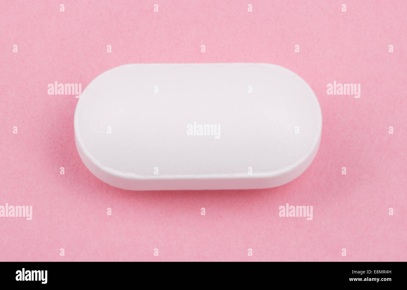 Pillola bianco su sfondo rosa Foto Stock