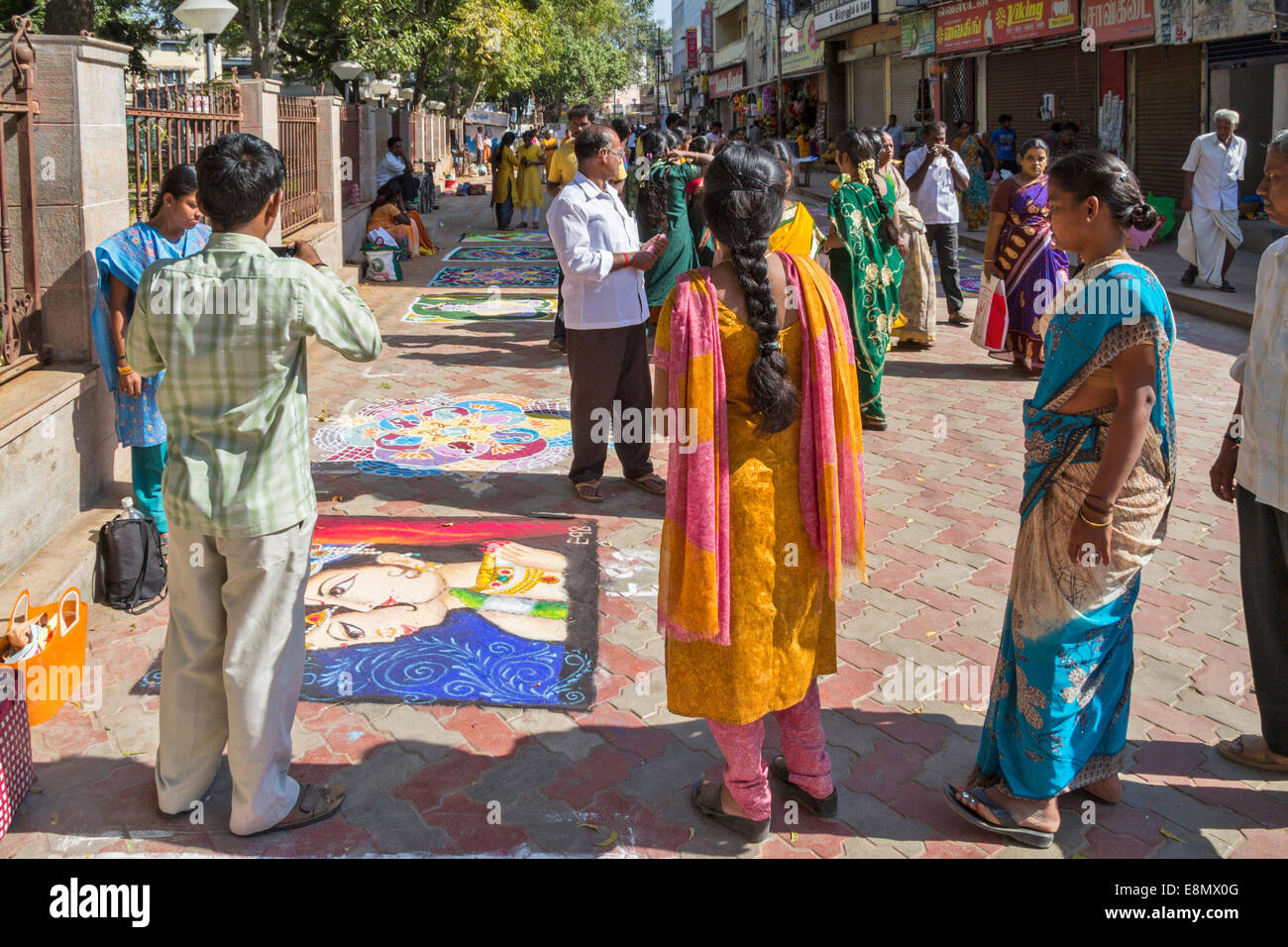 INDIAN STREET ART DI MADURAI popolo indiano di studiare e di utilizzare i telefoni cellulari per fotografare le foto sul marciapiede Foto Stock