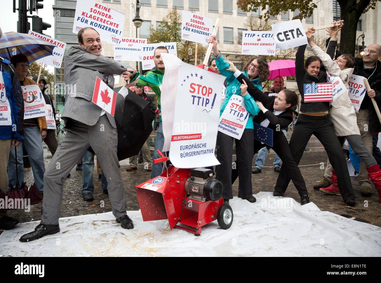 Berlino, Germania. Undicesimo oct, 2014. In una performance simbolica, la gente buttare i documenti in un grande pula-cutter durante una manifestazione di protesta contro l'UE accordi di libero scambio con gli Stati Uniti (TTIP) e Canada (CETA) di Berlino, Germania, 11 ottobre 2014. Le aziende sono attesi per ottenere ampie influenza politica attraverso gli accordi. Foto: Joerg Carstensen/dpa/Alamy Live News Foto Stock