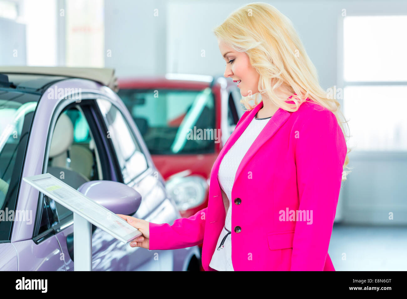La donna la scelta di auto per acquistare in concessionaria Foto Stock