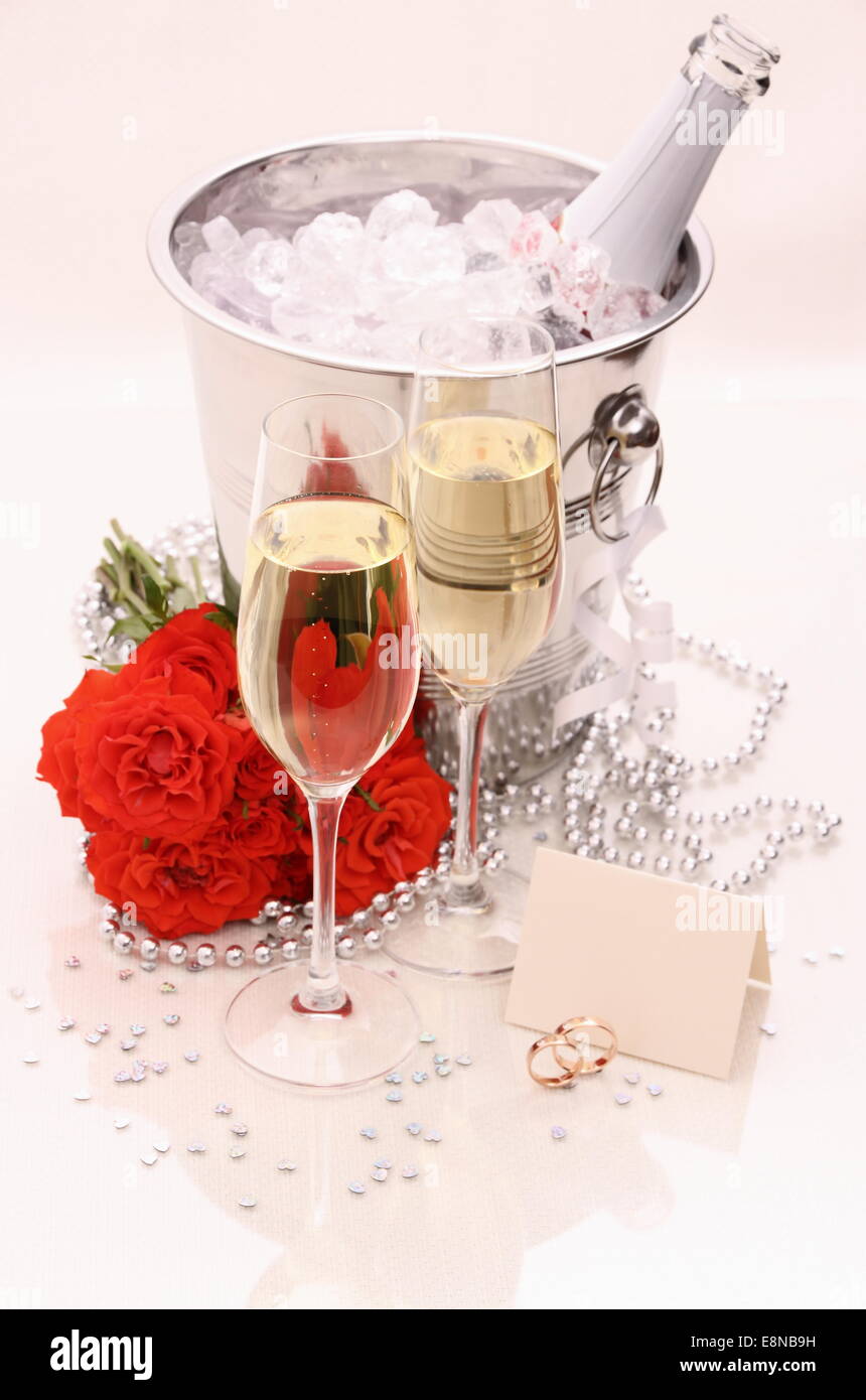Due golden gli anelli di nozze, scheda, champagne e rose rosse Foto Stock