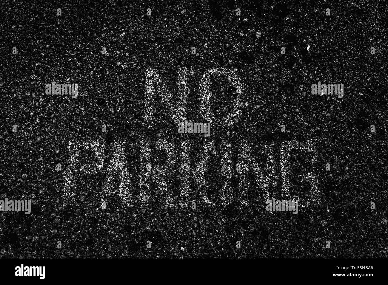 Angosciata e eroso nessun segno di parcheggio verniciato in bianco su strada asfaltata. Foto in bianco e nero Foto Stock