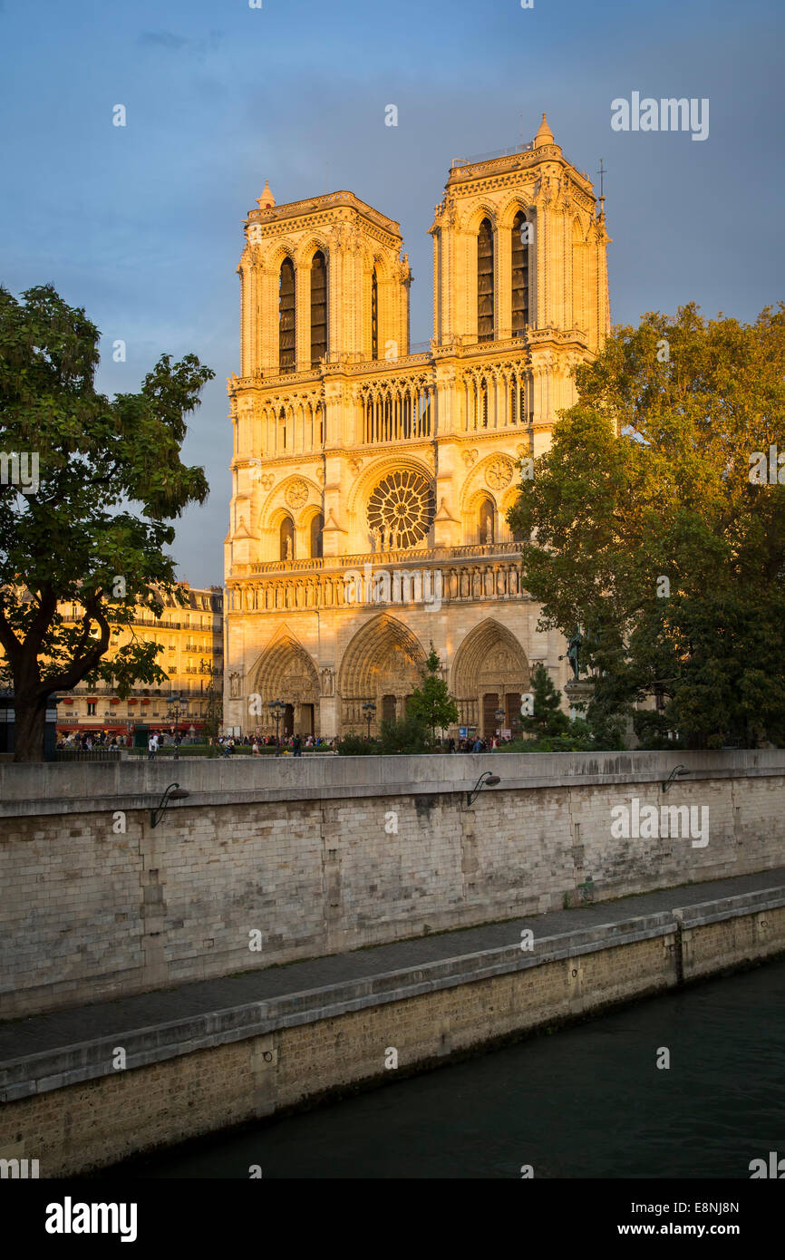 Impostando la luce solare sulla facciata anteriore della cattedrale di Notre Dame, Paris, Francia Foto Stock