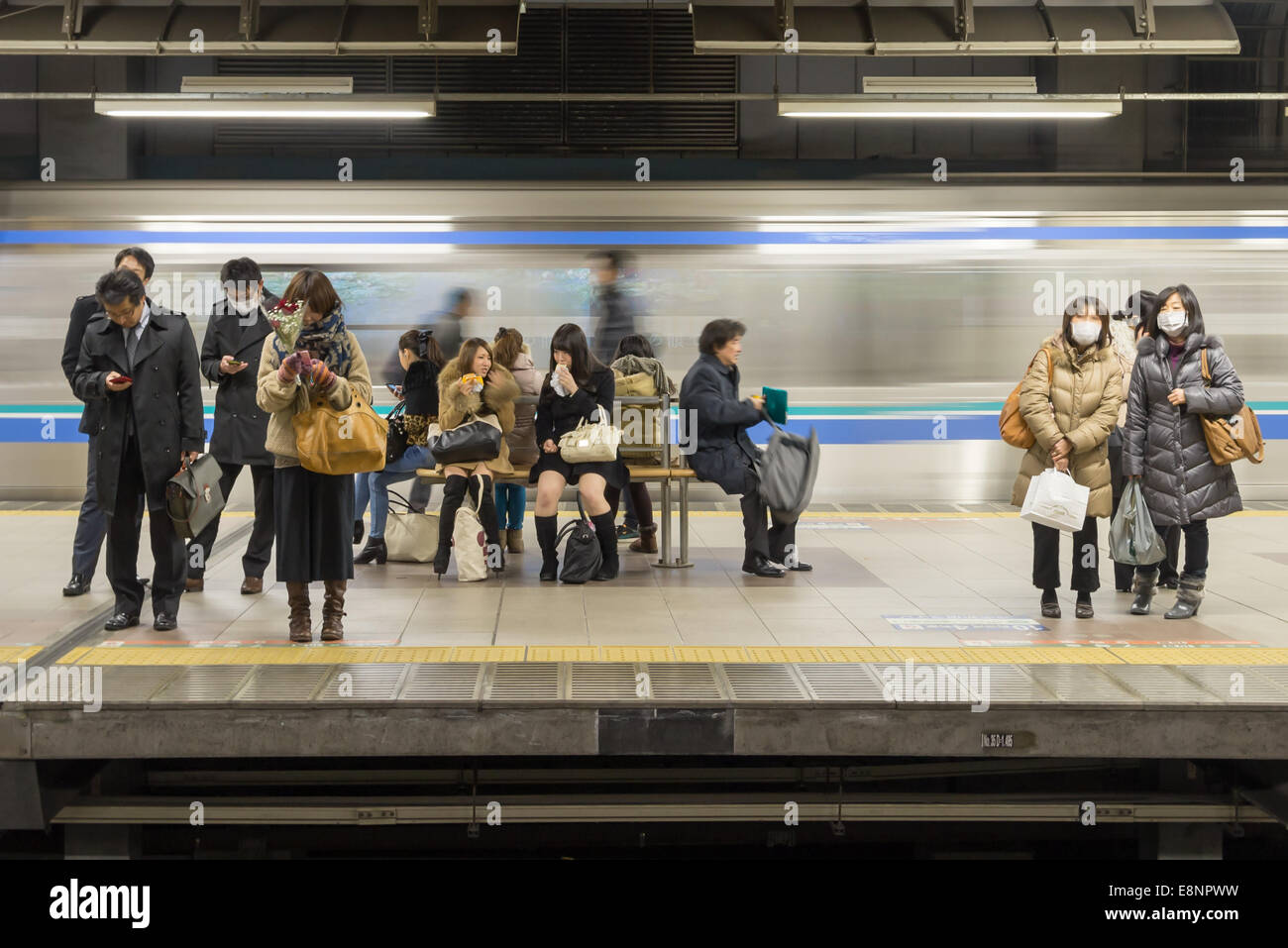 Stazione ferroviaria piattaforma con i passeggeri in attesa e movimento del treno, Ebisu la stazione JR di Tokyo Foto Stock